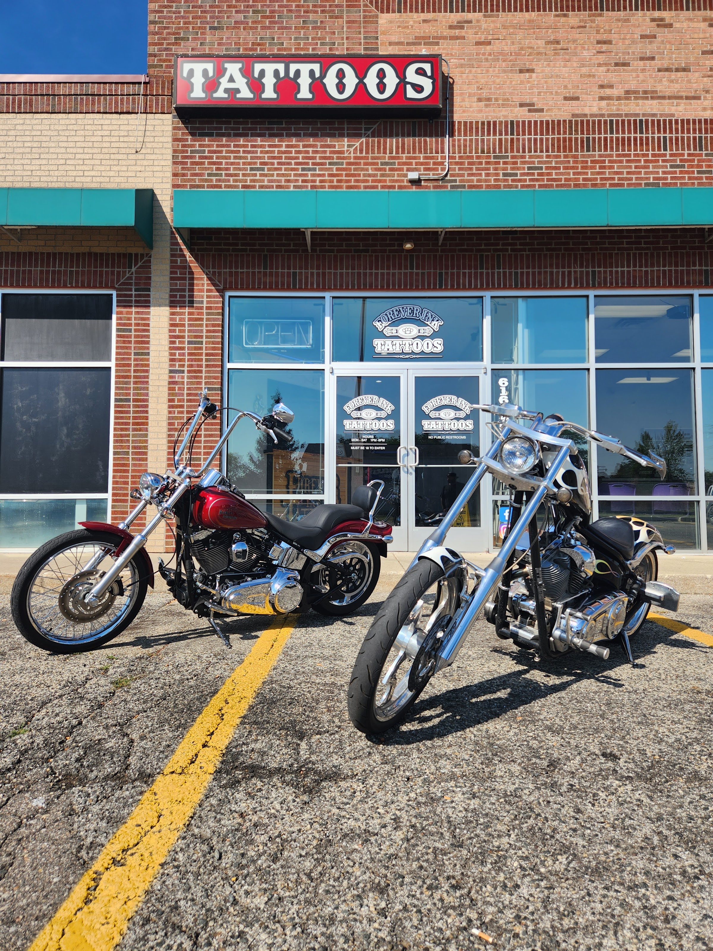 Forever Ink Tattoos storefront on Leonard St NW with two custom choppers parked out front