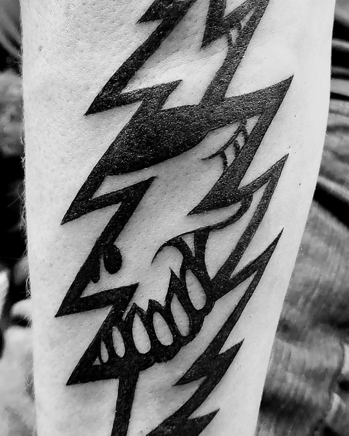 Bold black thirteen lightning-bolt flash tattoo on forearm